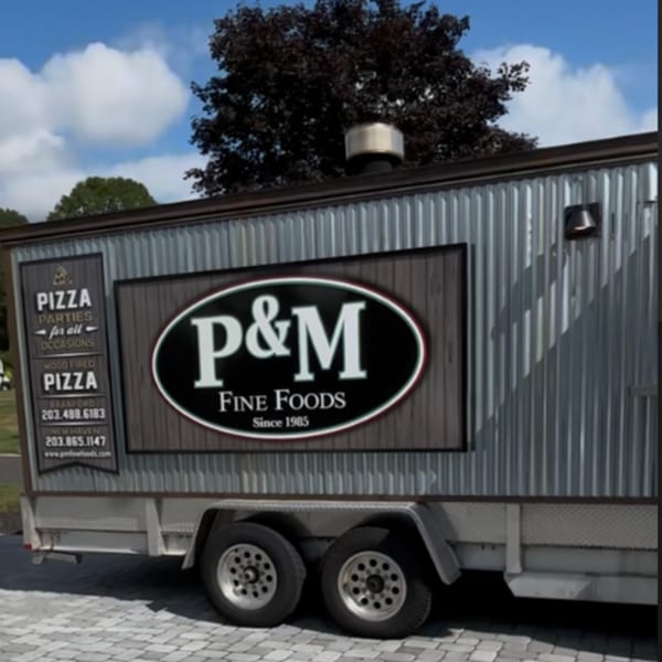 P&M Fine Foods pizza trailer with "P&M Fine Foods Since 1985" logo and pizza party details.