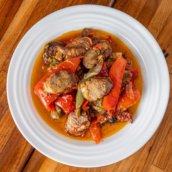 P&M Fine Foods' sausage and peppers dish, featuring sliced sausage, red and green bell peppers.